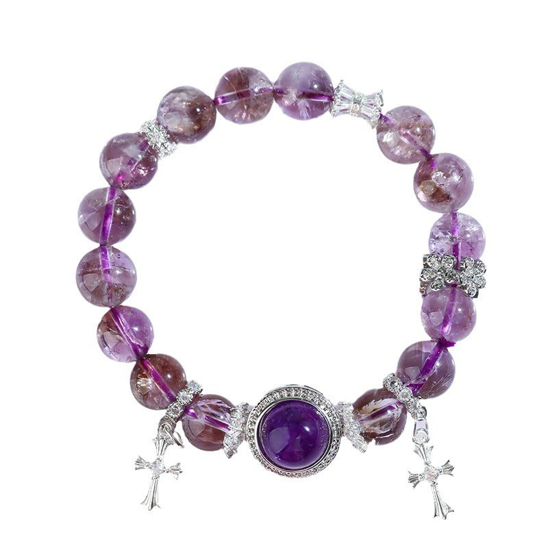Amethyst cross charm bracelet displayed flat on a pure white background — rich violet beads and pavé crystal center stone, clean and luxurious